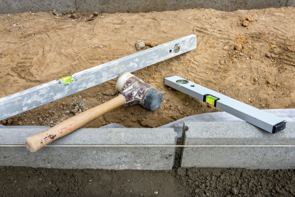 Randsteine setzten Randstein einklopfen und Betonstützen anbringen